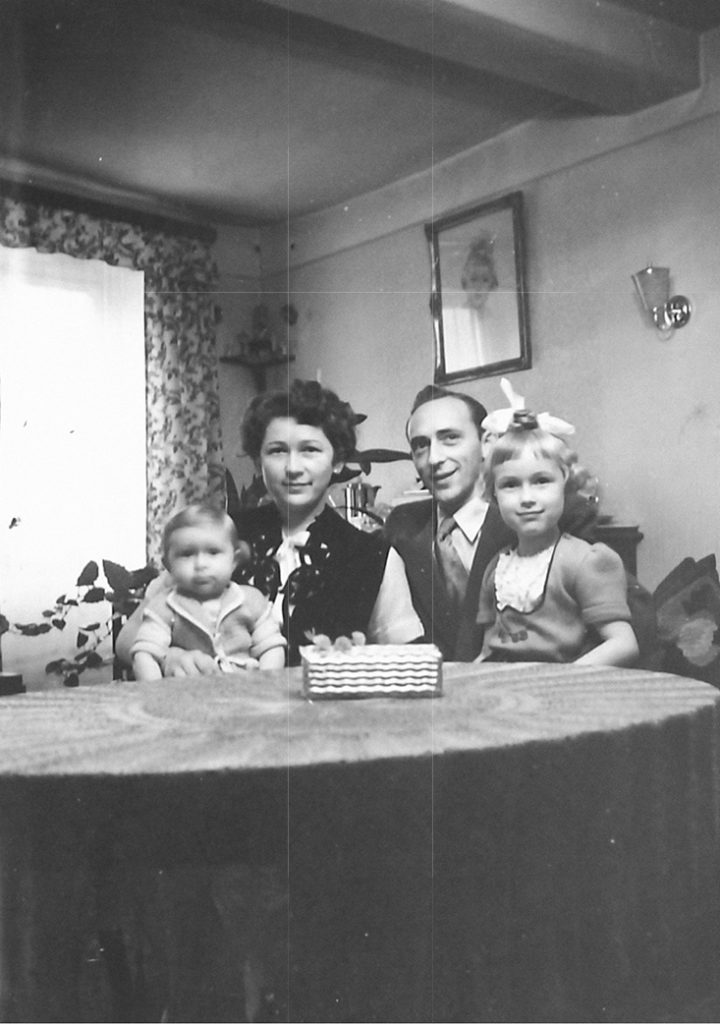 Familenfoto von Hilda, Josef Senior und ihren ersten beiden Kindern an einem Tisch.
