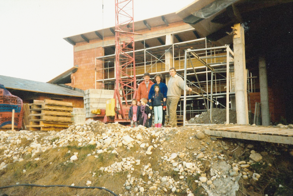 Familie Lehrbach vor der Baustelle. Alle lächeln in die Kamera.